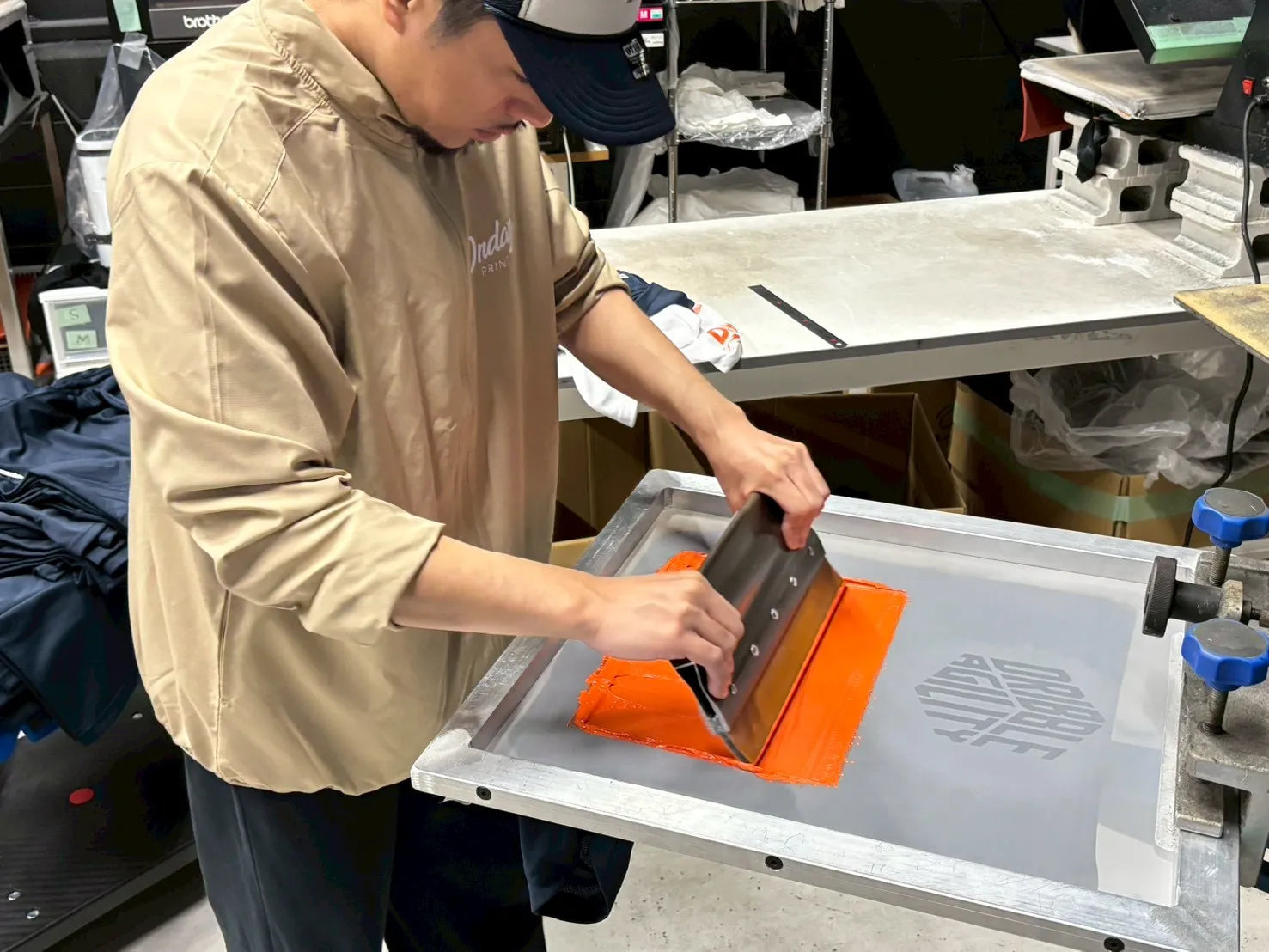 オンデープリント自社工場でシルクスクリーン印刷をするスタッフ